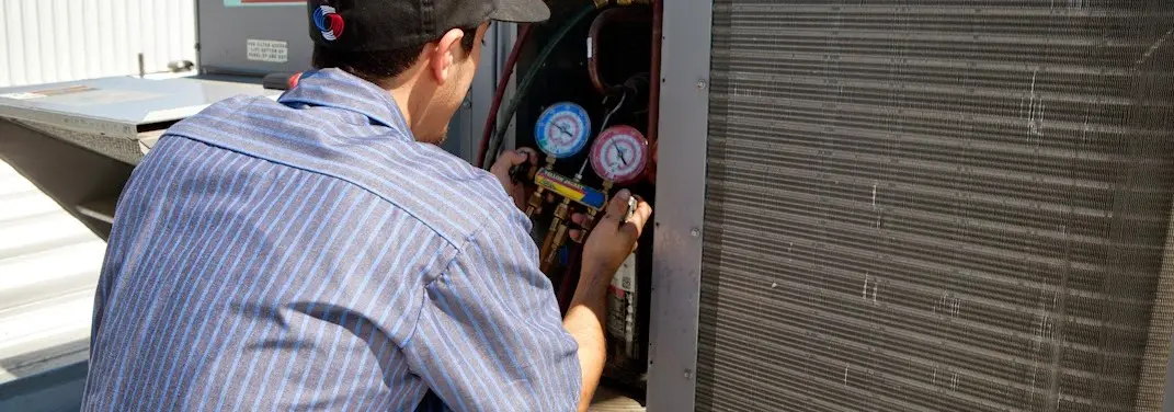HVAC technician servicing a condenser unit in Glenwood